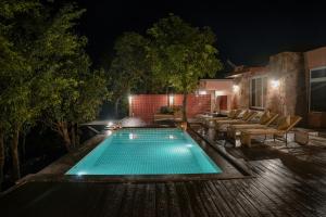 une piscine dans un jardin la nuit dans l'établissement Wild Forest, à Sasan Gir