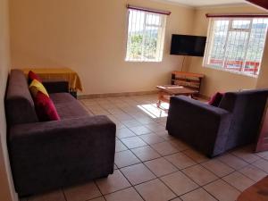 a living room with two couches and a tv at Ras Vill in Glencairn
