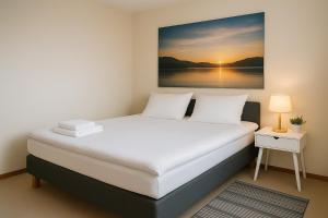a bedroom with a bed with a painting on the wall at Hotelli Vilho in Kotka