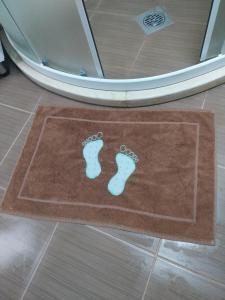 a brown bathroom rug with blue footprints on it at Park Apartment in Kochani