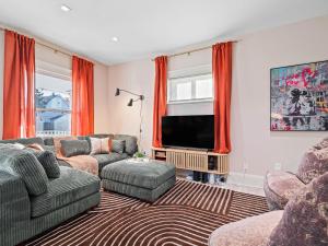 a living room with a couch and a television at Cleveland Escape - Hot Tub - Karaoke Machine - Sleeps 12 in Cleveland