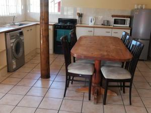 a kitchen with a wooden table with chairs and a stove at Ras Vill in Glencairn