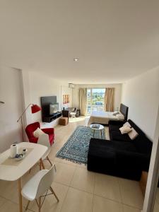 ein Wohnzimmer mit einer Couch, einem Bett und einem Tisch in der Unterkunft LOFT DE BAHIA GRANDE NORDELTA Tigre in Benavídez