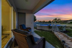 a porch with two chairs and a swimming pool at Into the Blue in Cape Coral Hospital Heliport