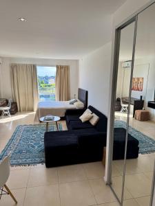 ein Wohnzimmer mit einer Couch und einem Bett in der Unterkunft LOFT DE BAHIA GRANDE NORDELTA Tigre in Benavídez