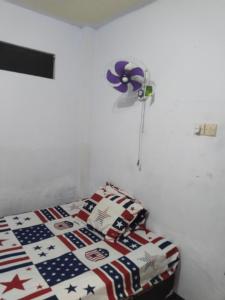 a bed in a room with an american flagitarianitarian at Penginapan SALSA in Ketapang