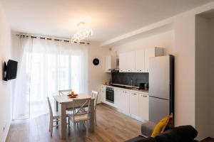 a kitchen with a table and a white refrigerator at Dimore Rosselli Suites in Fasano +70 photos