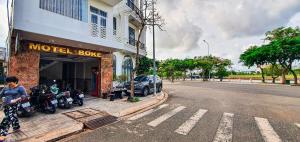 una donna in piedi davanti a un motel in una strada di Motel Bờ Kè a Ba Ria