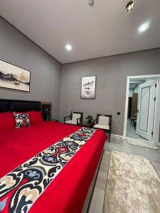 a bedroom with a large bed with a red blanket at Family House Hotel in Qarshi