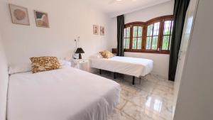 a bedroom with two beds and a window at Villa Mona Private pool and barbecue in Malaga in Málaga +22 photos