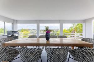 a wooden table with chairs and a vase with flowers at Casa di Mama Villa with Private Pool in Jan Thiel