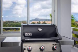 a grill sitting on a table in front of a window at Casa di Mama Villa with Private Pool in Jan Thiel