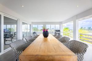 a dining room with a long wooden table and chairs at Casa di Mama Villa with Private Pool in Jan Thiel