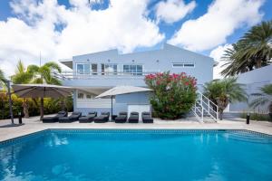 a swimming pool in front of a house at Casa di Mama Villa with Private Pool in Jan Thiel