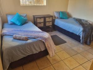 a room with two beds with blue pillows at Ras Vill in Glencairn
