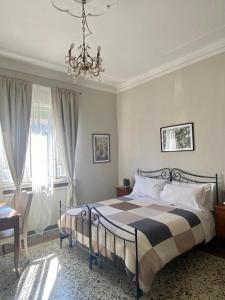 - une chambre avec un lit et un lustre dans l'établissement Villa Catelli, à Lucques