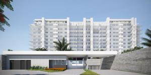 un grand bâtiment blanc devant un bâtiment dans l'établissement Apartamento Novo em São Lourenço, à Bertioga