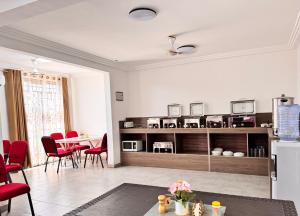 a living room with a table and red chairs at Kwanskrom Villa Biggies Homes in Winneba