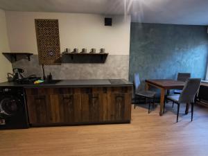 a kitchen with a counter and a table and chairs at Nad Dachami Poznania - apartament nr 7 in Poznań