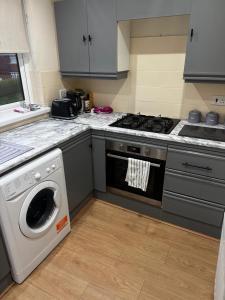 a kitchen with a stove and a washing machine at Central 2 bed Apartment Bangor in Groomsport