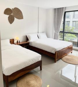 two beds in a room with a window at 22 Homestay-near AEON Mall 3 & Techo International Aiport in Ta Khmau