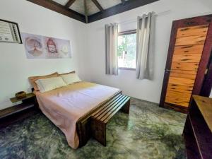 ein Schlafzimmer mit großem Bett und Fenster in der Unterkunft Casa Recanto ViVaMar - 3 bedroom house, 10 min from the beach in Barra Grande