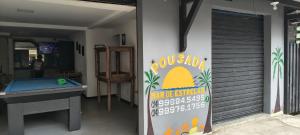 Ein Raum mit einer Tischtennisplatte und einem Schild an der Wand in der Unterkunft Pousada Mar De Estrelas in Angra dos Reis