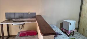 Kleines Zimmer mit einem Waschbecken und einem Schreibtisch. in der Unterkunft Pousada Mar De Estrelas in Angra dos Reis