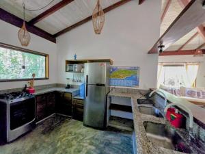 eine Küche mit einem Kühlschrank aus Edelstahl in einem Zimmer in der Unterkunft Casa Recanto ViVaMar - 3 bedroom house, 10 min from the beach in Barra Grande