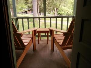 2 bancs assis sur une terrasse couverte avec une table dans l'établissement Clove Cottages, à Accord