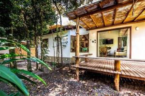 eine Holzbank vor einem Haus in der Unterkunft Casa Recanto ViVaMar - 3 bedroom house, 10 min from the beach in Barra Grande