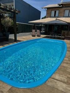 einen großen blauen Pool auf einer Holzterrasse in der Unterkunft Refúgio Rustico em Penha in Penha