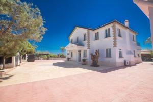 a large white house on a brick driveway at Papas Family Villa in Paralimni