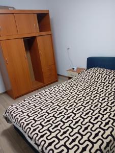 une chambre avec un lit et une armoire en bois dans l'établissement Mircea, à Craiova 2 autres photos