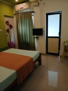 特里凡得琅Spring Valley Hotels的一间设有两张床、一个窗口和一扇门的房间