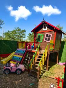 a playground with a play house and a slide at Beaver lodge - Dabrova Koliba in Bijeljina