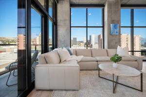 ein Wohnzimmer mit einem weißen Sofa und großen Fenstern in der Unterkunft Luxury 2BR 2BA Penthouse-Pool, Gym, Pkg, Views! in Salt Lake City + 37 Fotos