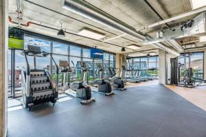 ein Fitnessstudio mit Cardiogeräten in einem Gebäude mit Fenstern in der Unterkunft Luxury 2BR 2BA Penthouse-Pool, Gym, Pkg, Views! in Salt Lake City