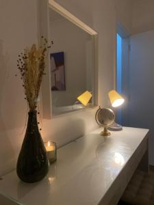 eine Vase mit Blumen auf einem Tisch mit einer Lampe in der Unterkunft A Janela do Cantinho in Reguengos de Monsaraz + 5 Fotos