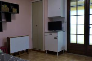 een kamer met een tv op een dressoir en een deur bij Charming studio with balcony in Sanary-sur-Mer in Sanary-sur-Mer
