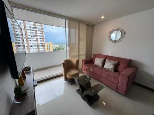 a living room with a red couch and a large window at Club house 1105-Apartamento Fundadores con balcón, piscina, gym in Armenia