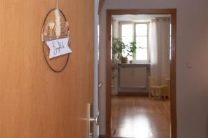 a door with a sign hanging on a wall at Gemütlich gestaltetes, familiengeführtes Apartment mit Burgblick in Burghausen
