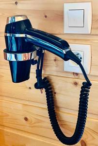 un téléphone noir est accroché au mur dans l'établissement Chalet la montagne numero 10, à La Joue du Loup