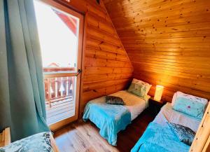 une petite chambre avec deux lits dans une cabane en rondins dans l'établissement Chalet la montagne numero 10, à La Joue du Loup 18 autres photos