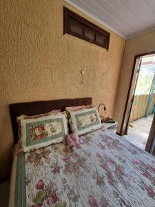 ein Bett mit zwei Kissen und einem Stofftier darauf in der Unterkunft Coração de São Gabriel in São Gabriel
