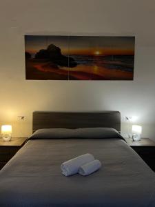 a bedroom with a bed with two lamps and a painting at A casa di Rita in Agropoli