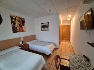 ein Hotelzimmer mit zwei Betten und einem Tisch in der Unterkunft Hotel Bon Lloc in Ulldecona