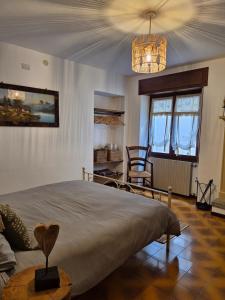 ein Schlafzimmer mit einem großen Bett und einem Kronleuchter in der Unterkunft Appartamento in struttura indipendente Appartamenti di Mezzo in Cecino