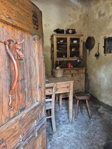 Zimmer mit einem Holztisch und einer Holztür in der Unterkunft Appartamento in struttura indipendente Appartamenti di Mezzo in Cecino