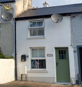 a white house with a green door and a dog in a window at Blarney Street in Cork